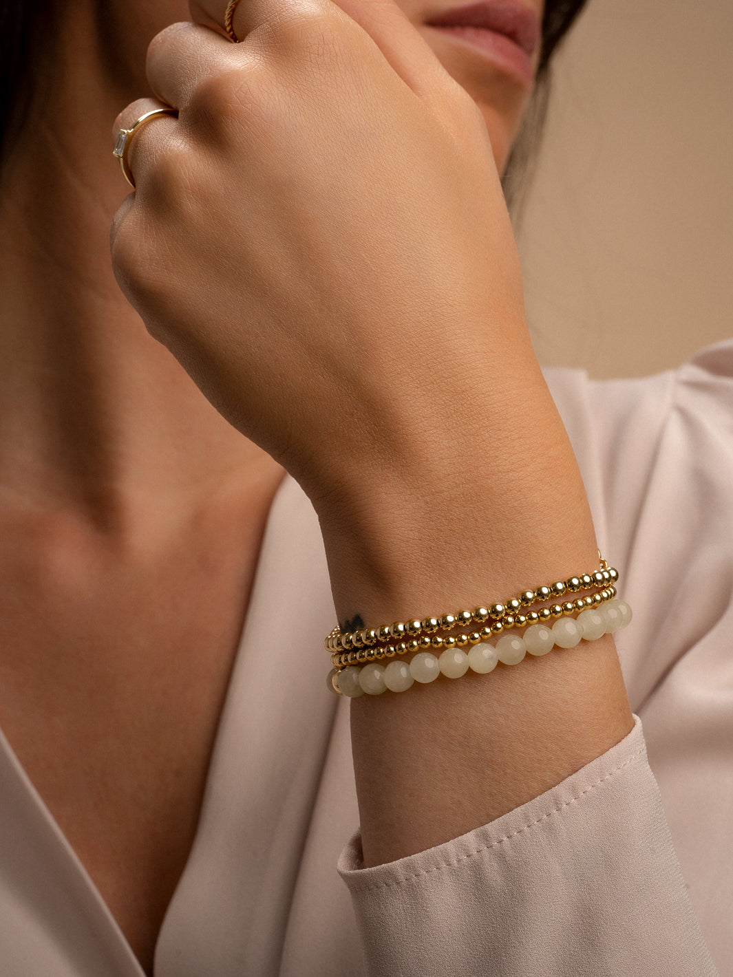 Pols met armbanden stack kleur beige agaat met gouden kralen 